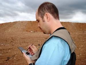 Minas inspector with palmtop at landfill site